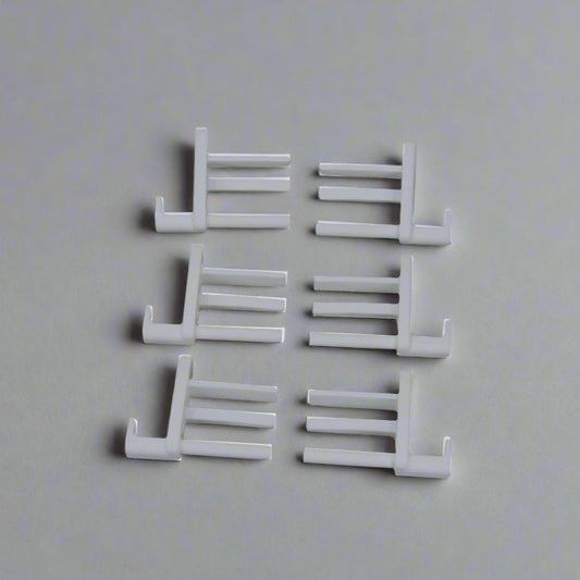 Set of white plastic hooks on a gray background